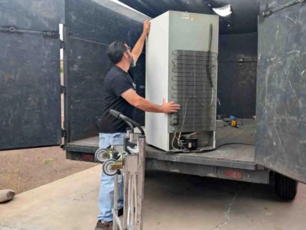 Loading an old refrigerator for removal during a junk removal service in Phoenix